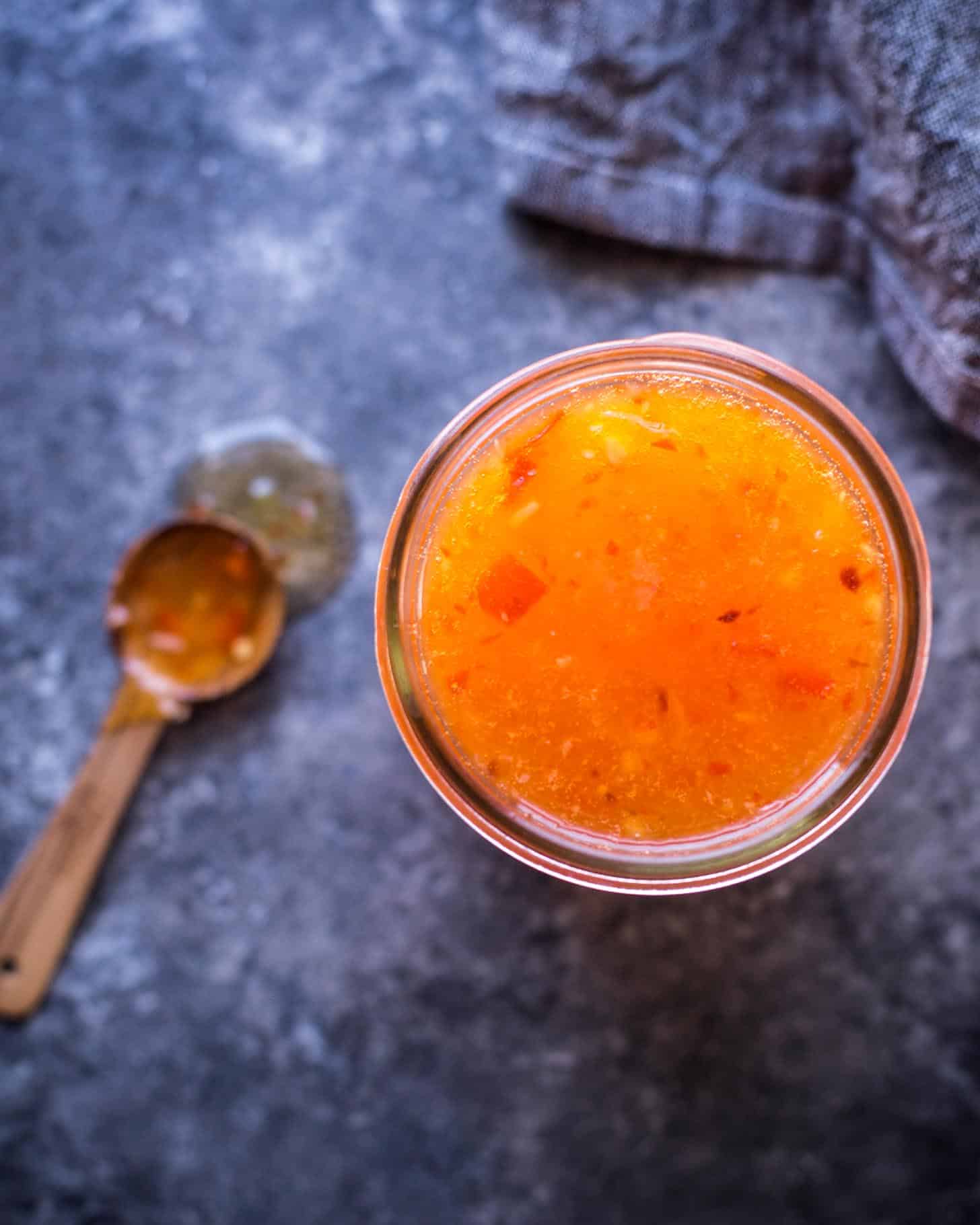 overhead image of pineapple dipping sauce in a clear glass jar