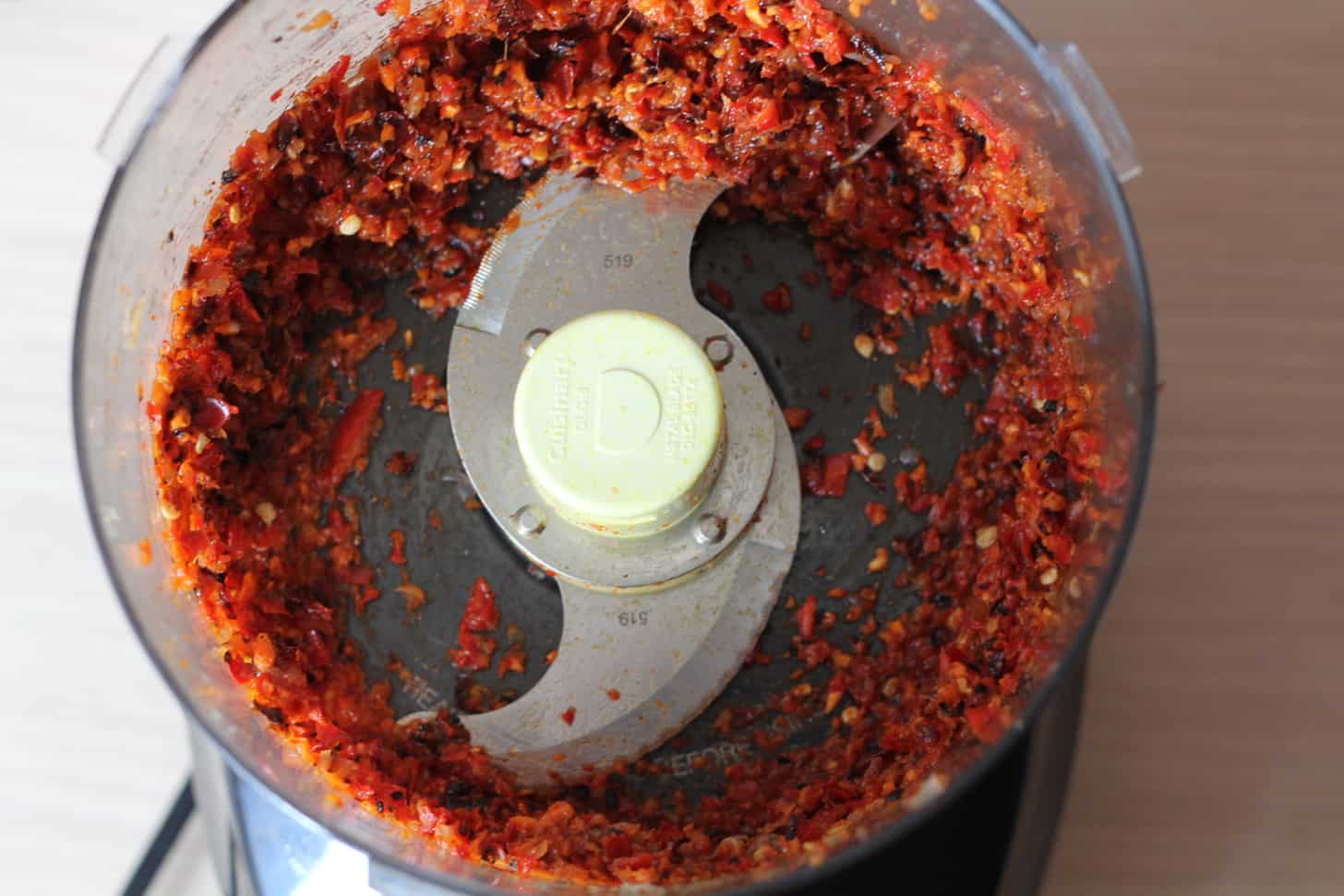overhead image of red chili paste in a food processor bowl
