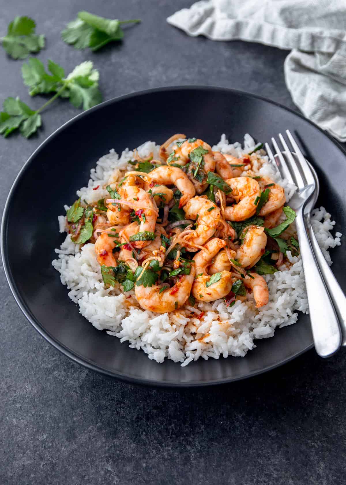 shrimp salad over rice in a black bowl