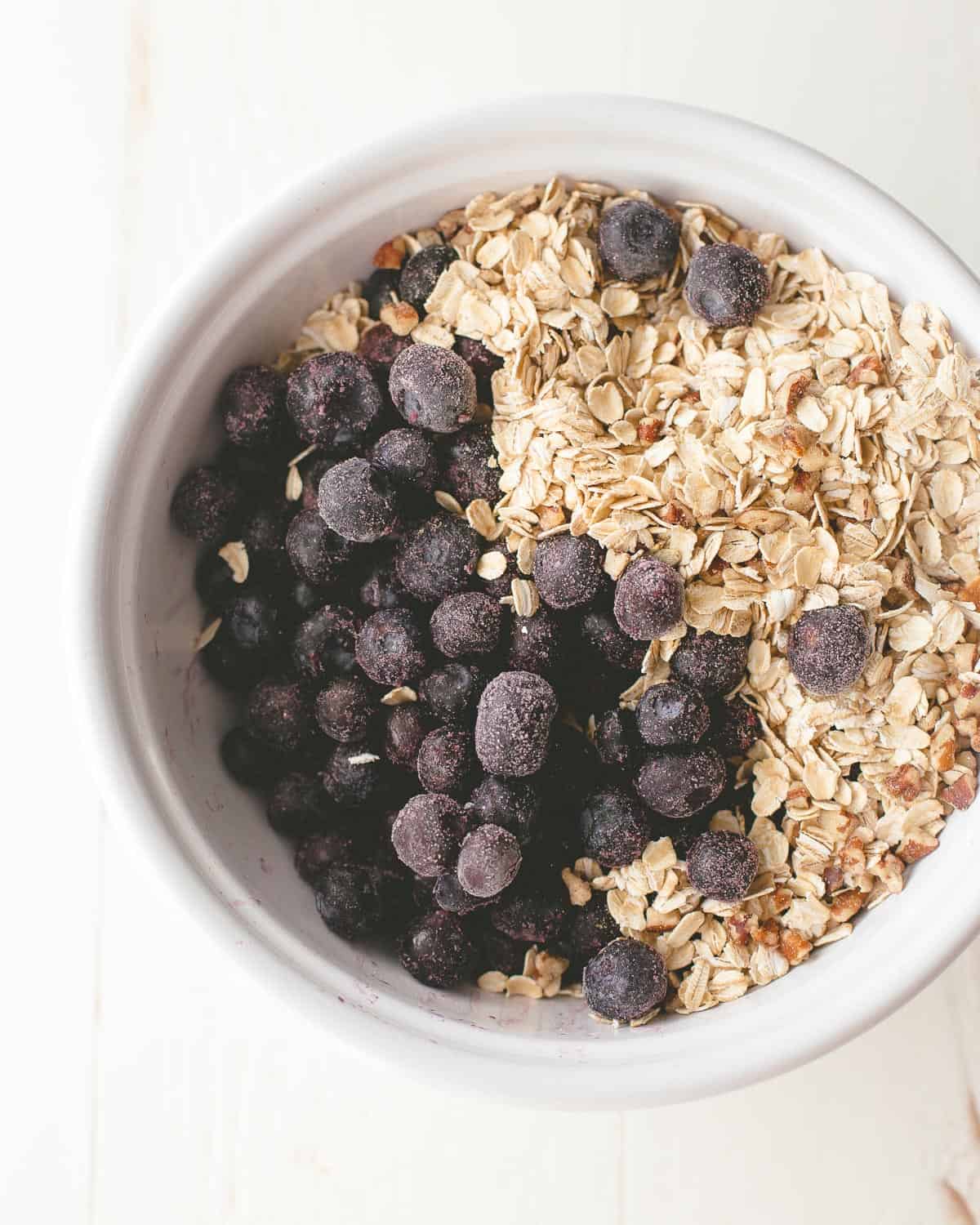 ingredients for blueberry oatmeal in a white bowl