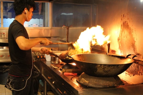 a chef cooking pad thai in a wok
