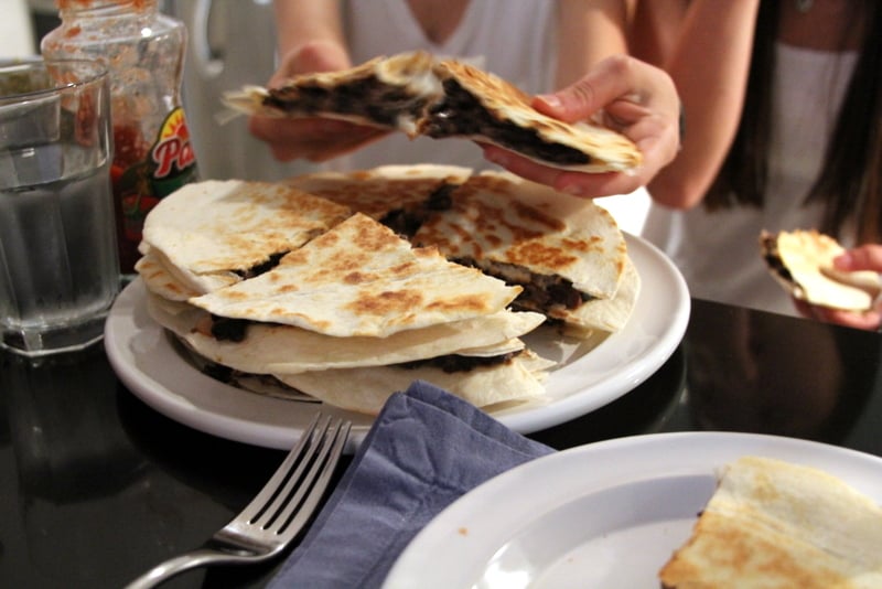 a stack of black bean quesadillas on a white plate