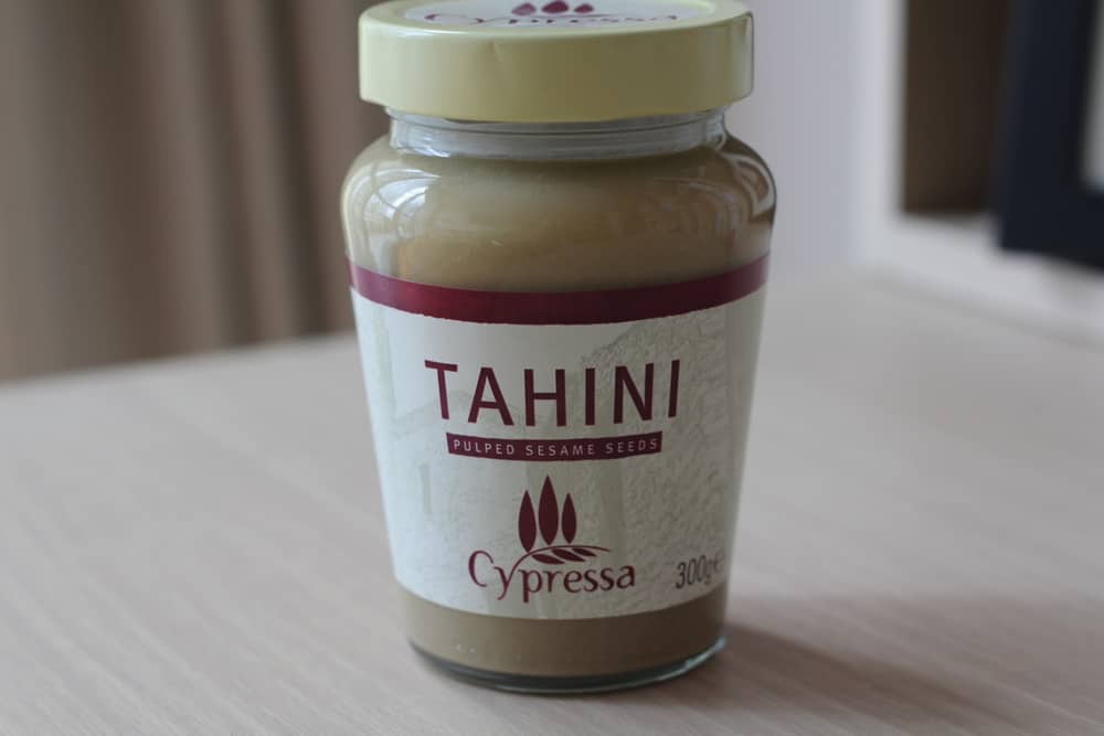 a jar of tahini on a white countertop