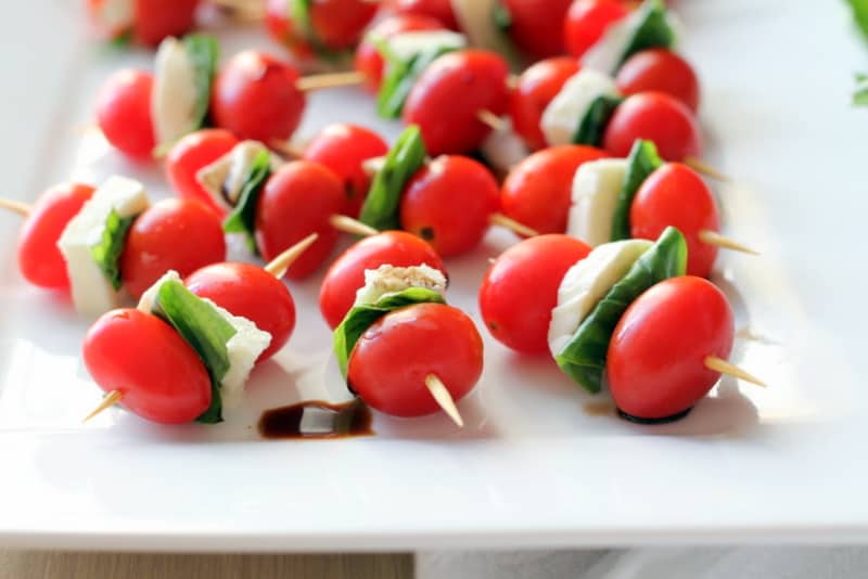 caprese skewers on a white rectangular tray