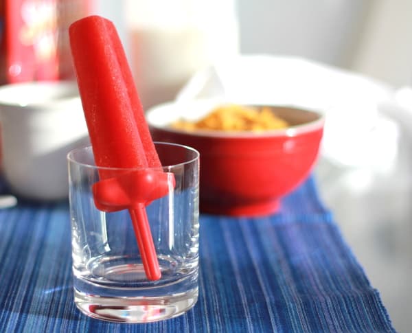 a watermelon popsicle in a clear glass