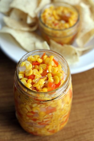 overhead image of a glass mason jar full of corn salsa