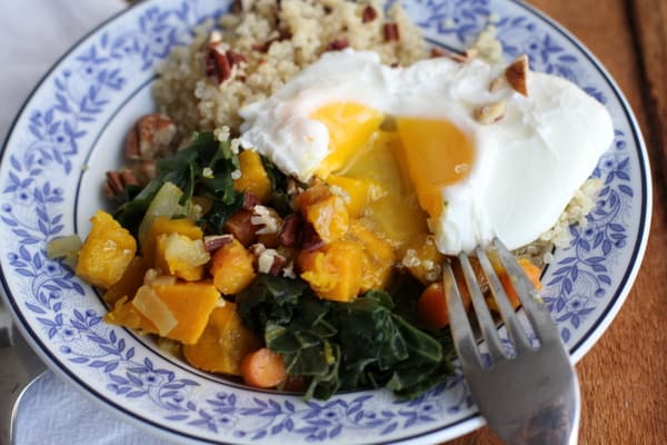 a fried egg on top of vegetables in a blue and white bowl