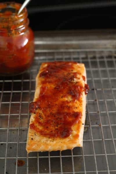 Prepping raw salmon with red curry paste