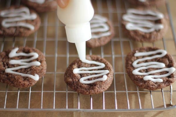 adding glaze to cookies on a cooling rack