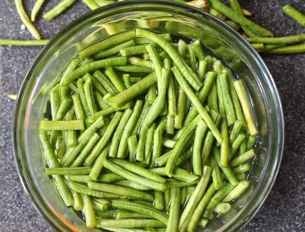 uncut green beans in a clear glass bowl