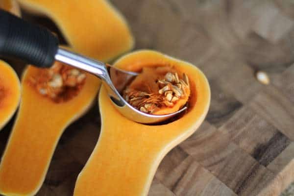 scooping the seeds out of a butternut squash