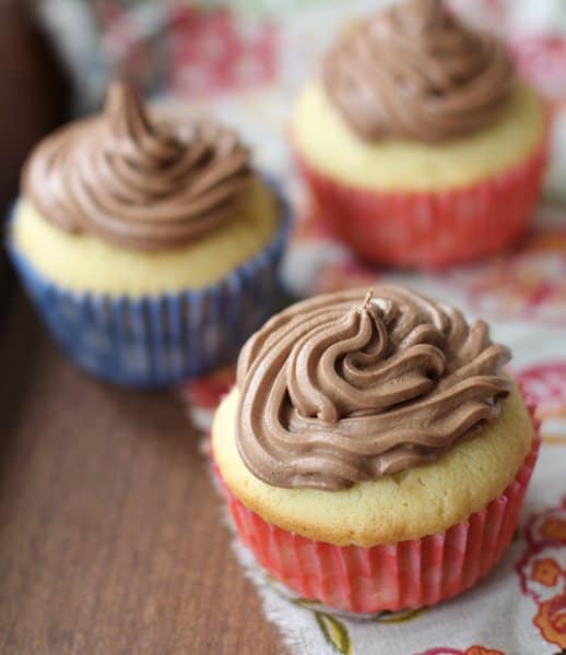 cupcakes topped with frosting in red and blue paper liners