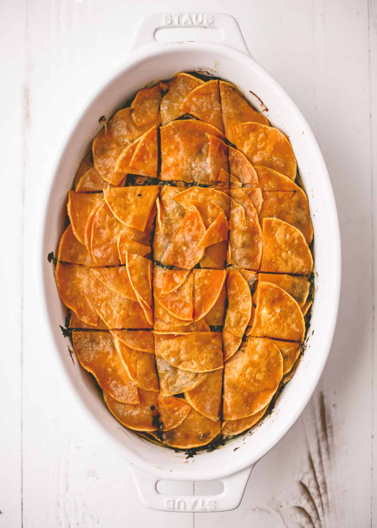 overhead image of squash and spinach casserole in an oval baking dish