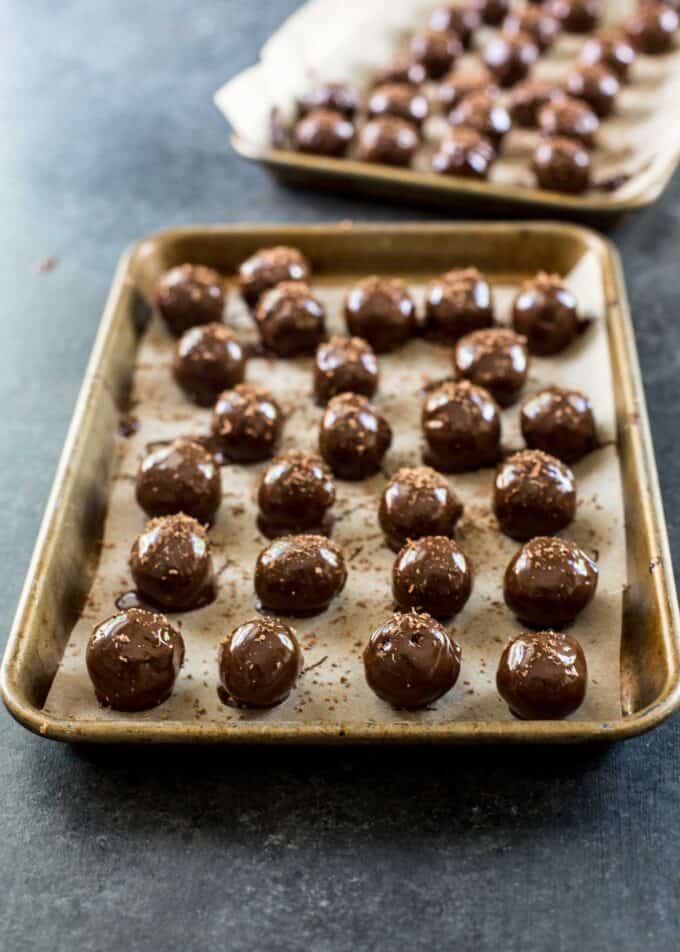 chocolate dipped truffles on a parchment lined sheet pan