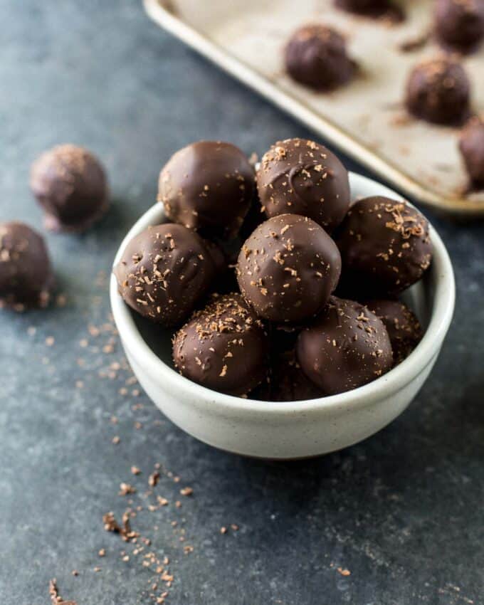 a white bowl of chocolate dipped truffles