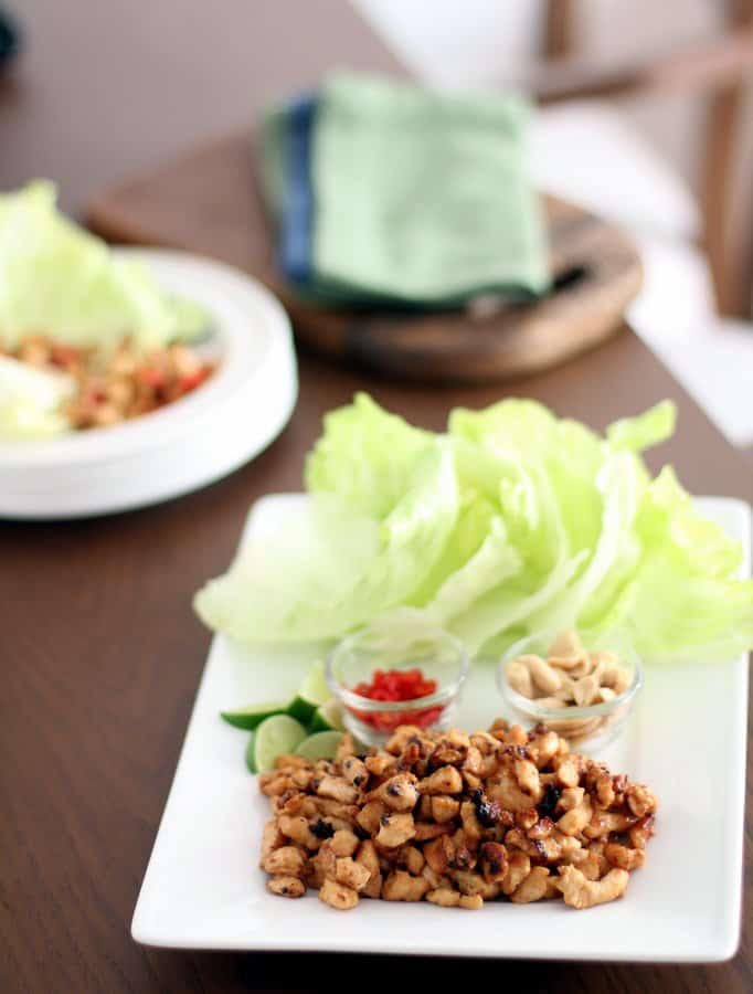 lettuce, chicken and toppings on a white cutting board