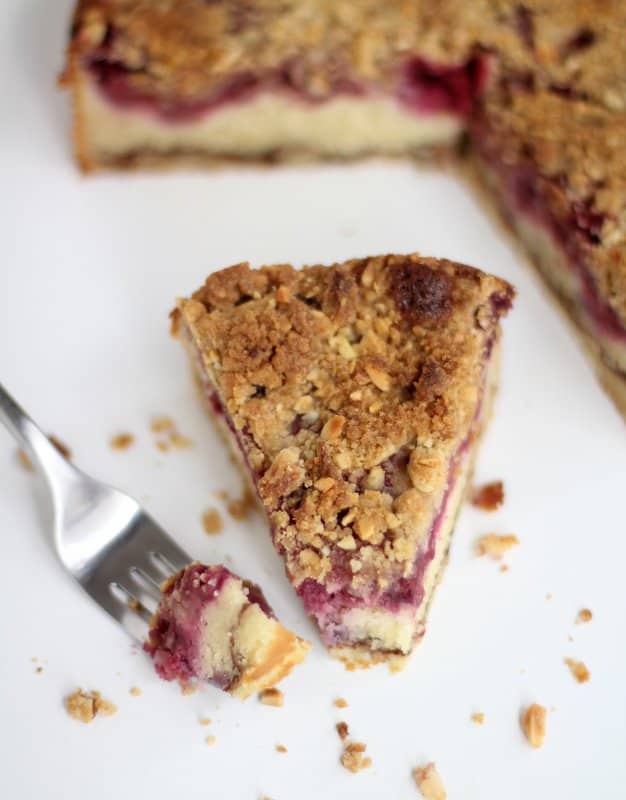 a fork and a slice of raspberry cake on a white countertop