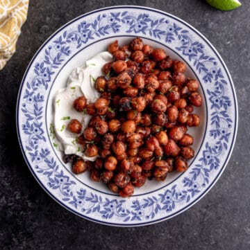 overhead image of crispy chickpeas over yogurt in a blue and white bowl