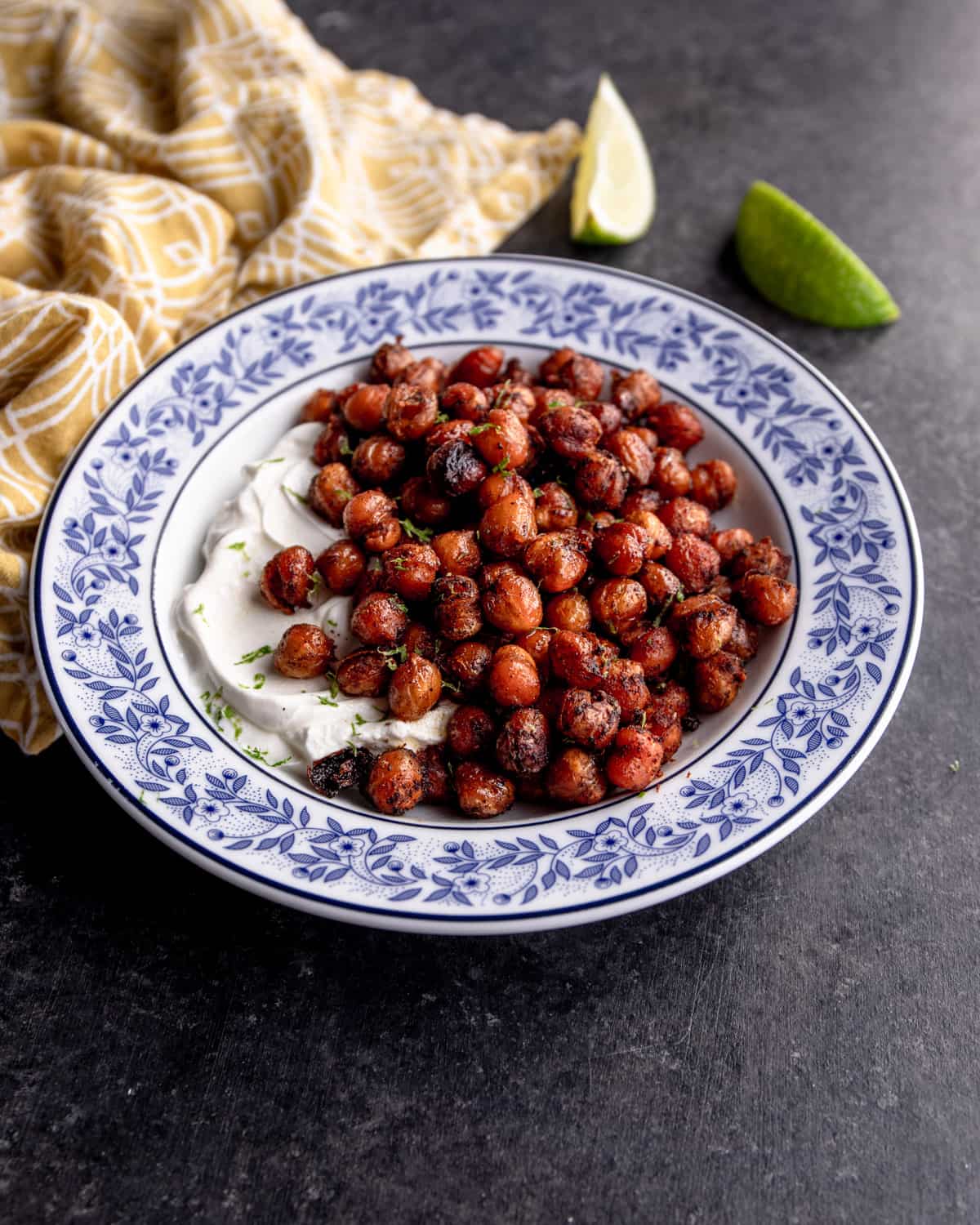 crispy chickpeas over plain yogurt in a blue and white bowl