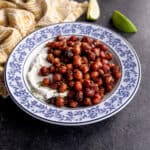 square image of crispy chickpeas over yogurt in a blue and white bowl