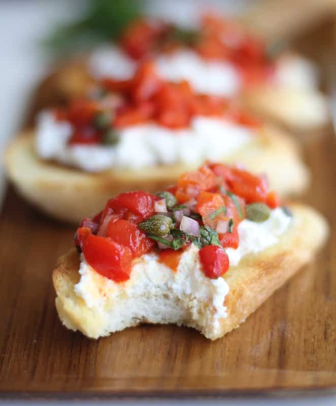 close up image bruschetta with a bite taken out of it