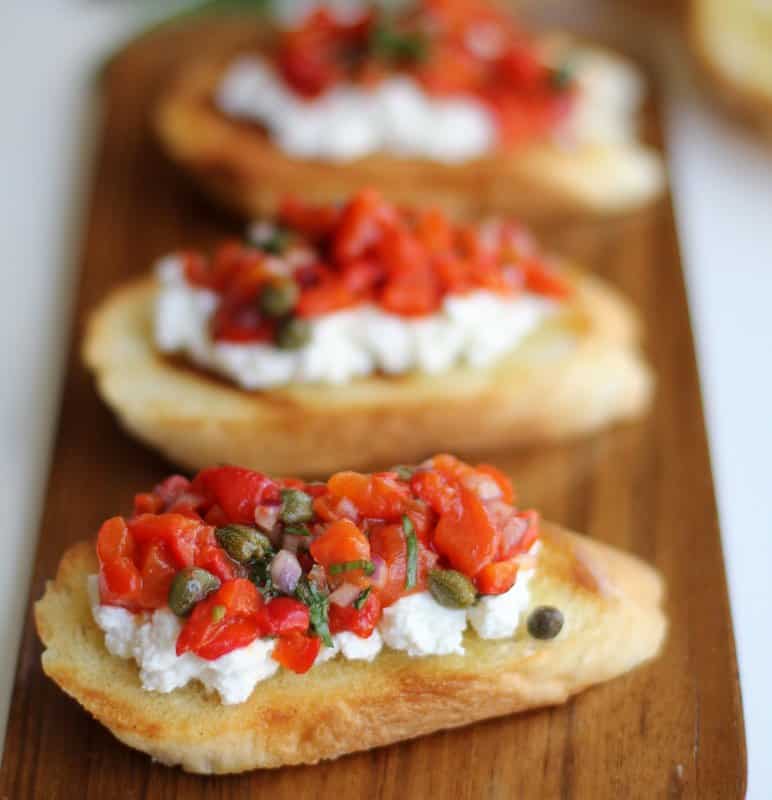 Roasted Red Pepper and Ricotta Bruschetta on a wooden tray