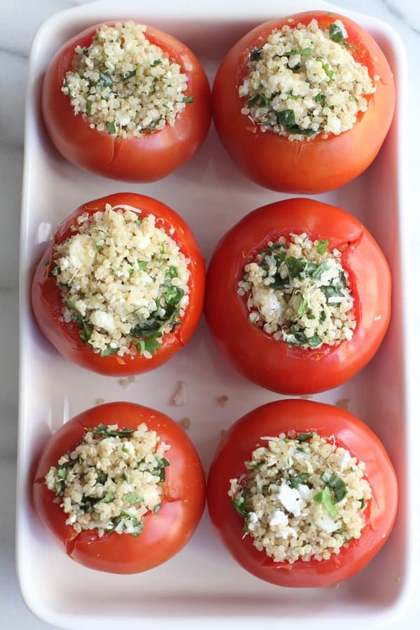 stuffed tomatoes in a white baking dish