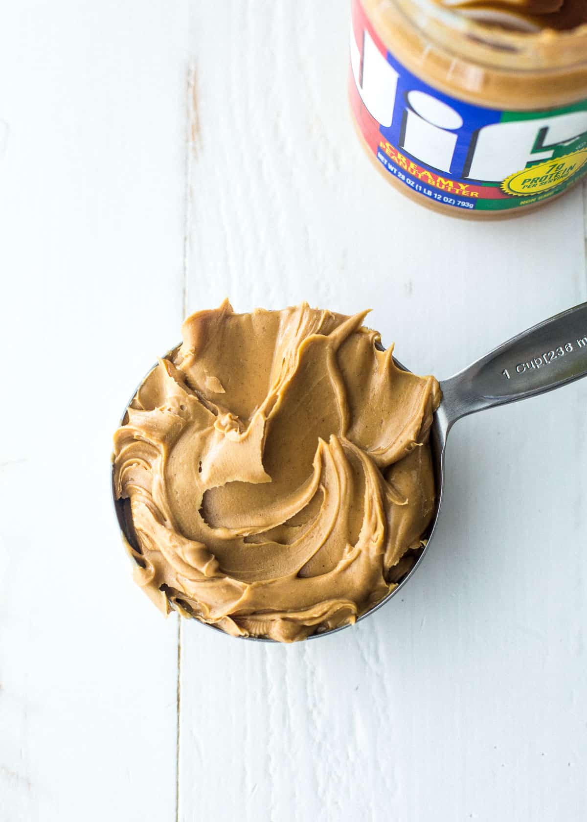 overhead image of smooth peanut butter in a measuring cup