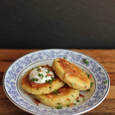 potato pancakes with sour cream on a blue and white plate