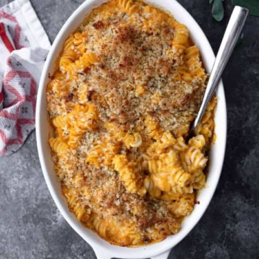 sweet potato mac and cheese in a white oval dish with breadcrumb topping