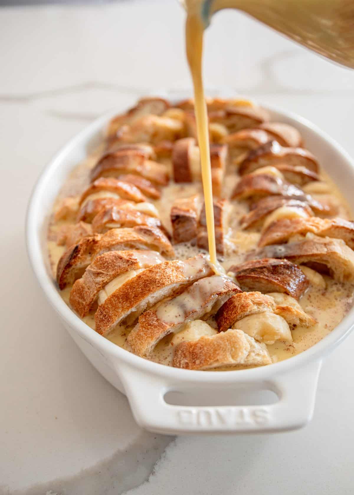 pouring custard over french toast casserole