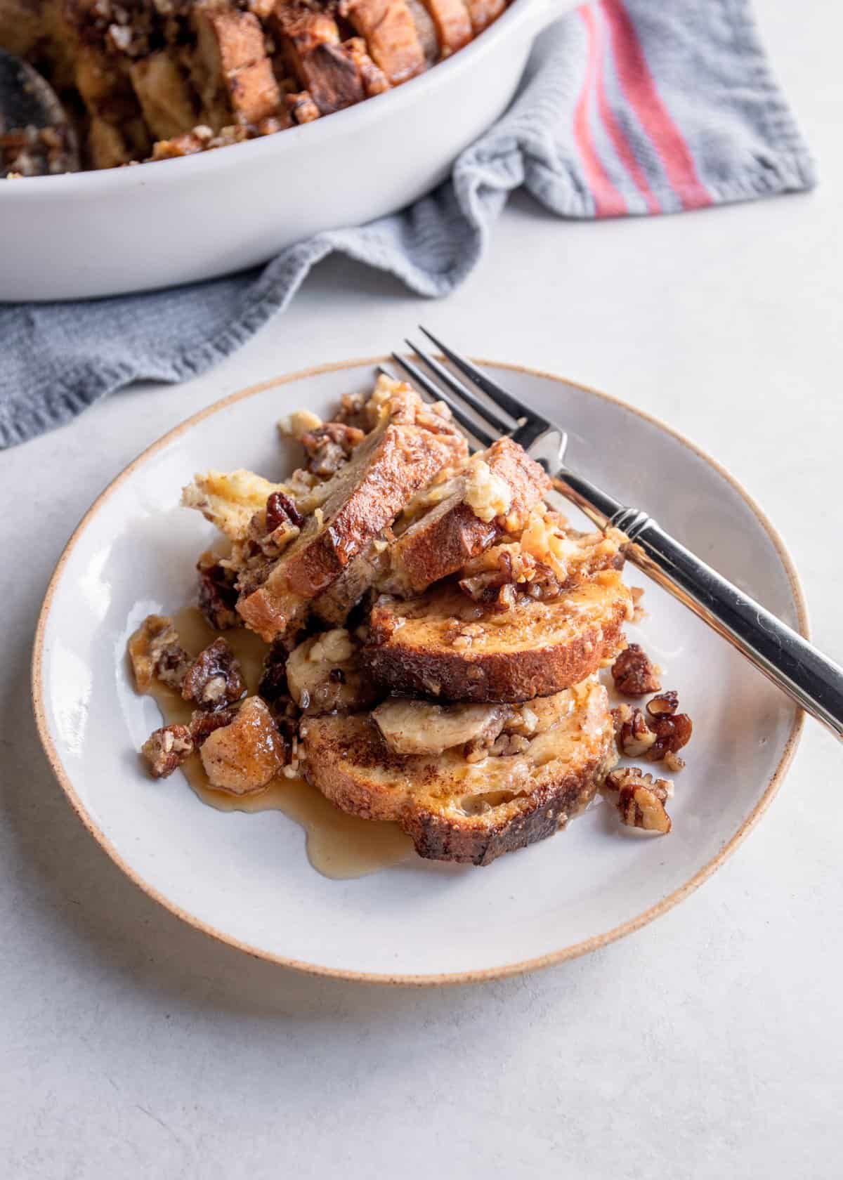 slices of banana french toast on a white plate with a fork