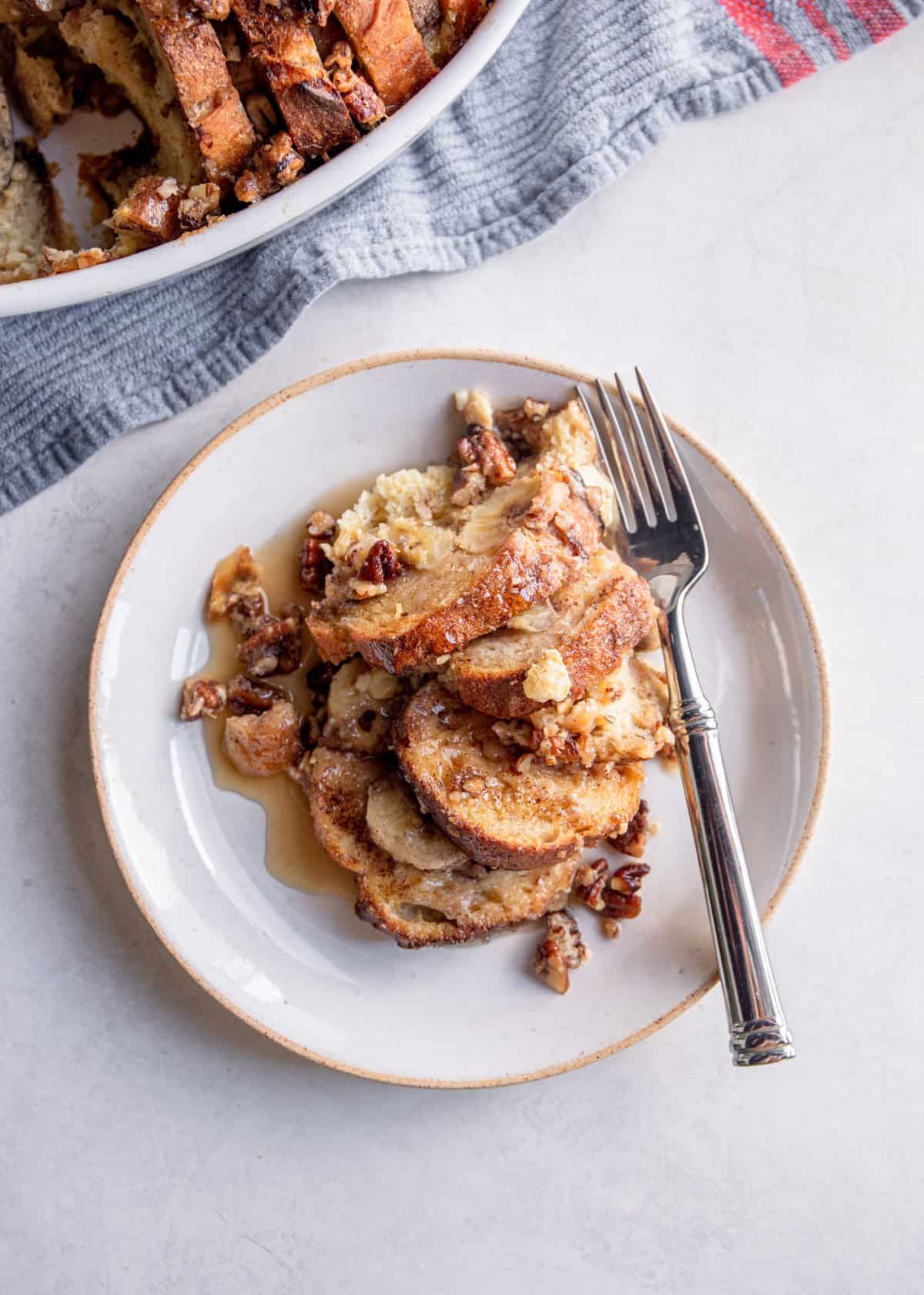 overhead image of banana french toast on a white plate with a fork