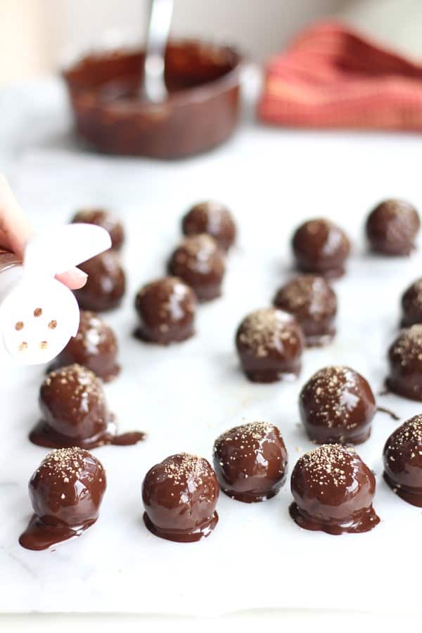 sprinkling cocoa powder on truffles