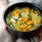 orzo soup in a black bowl