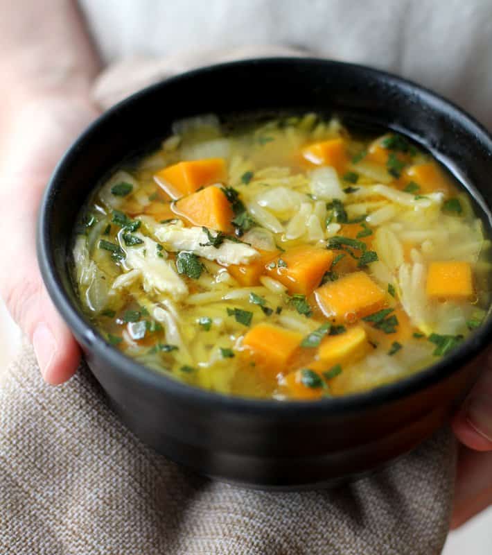 chicken, butternut squash and orzo soup in a black bowl