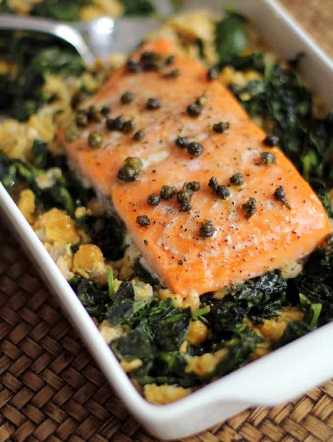 salmon and greens in a white baking dish