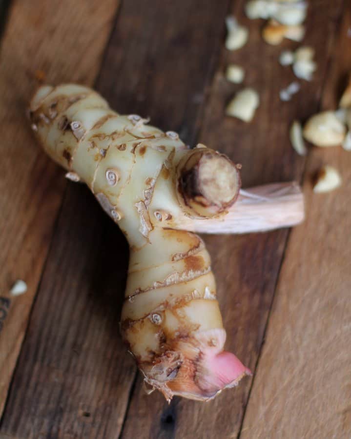 overhead image of galangal on a wooden cutting board