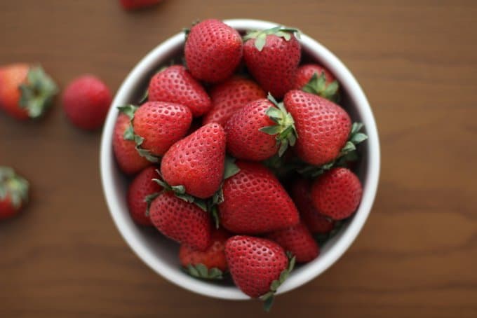 a white bowl of strawberries