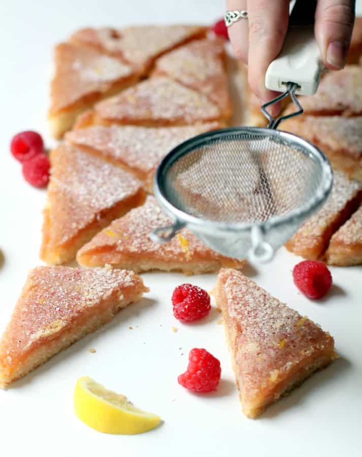 spreading powdered sugar on lemon bars