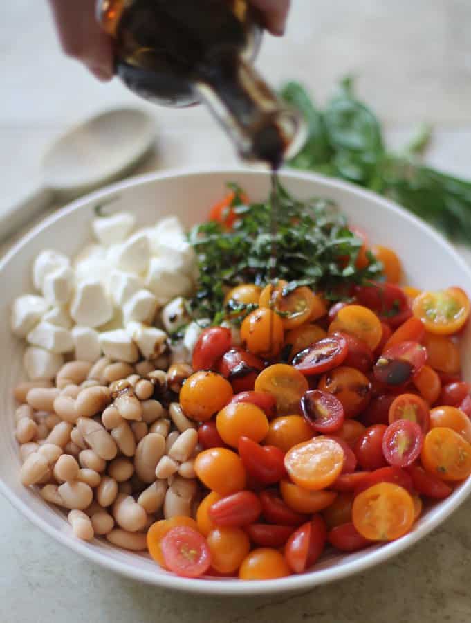 white beans, tomatoes, mozzarella and basil in a white bowl