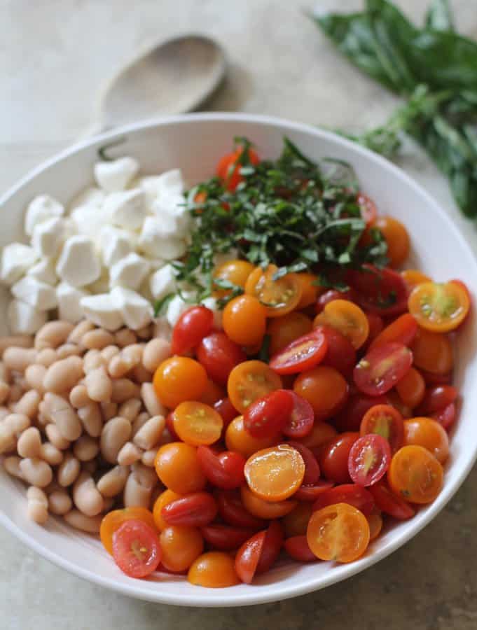 white beans, tomatoes, basil and mozzarella in a white bowl