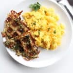 waffle iron hash browns on a white plate with scrambled eggs