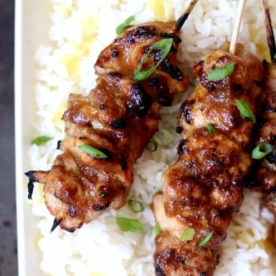 close up of honey garlic chicken skewers on a bed of pineapple rice