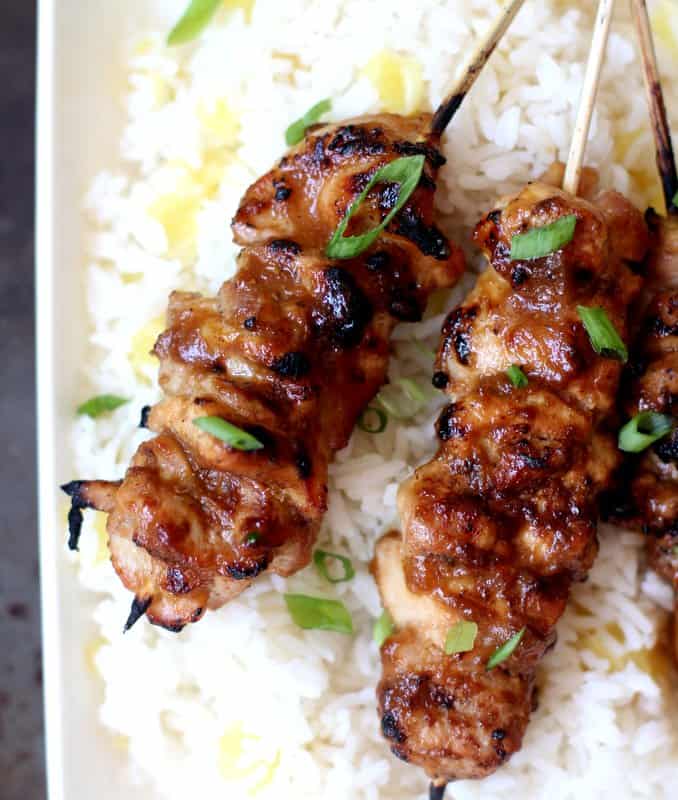 close up of honey garlic chicken skewers on a bed of pineapple rice