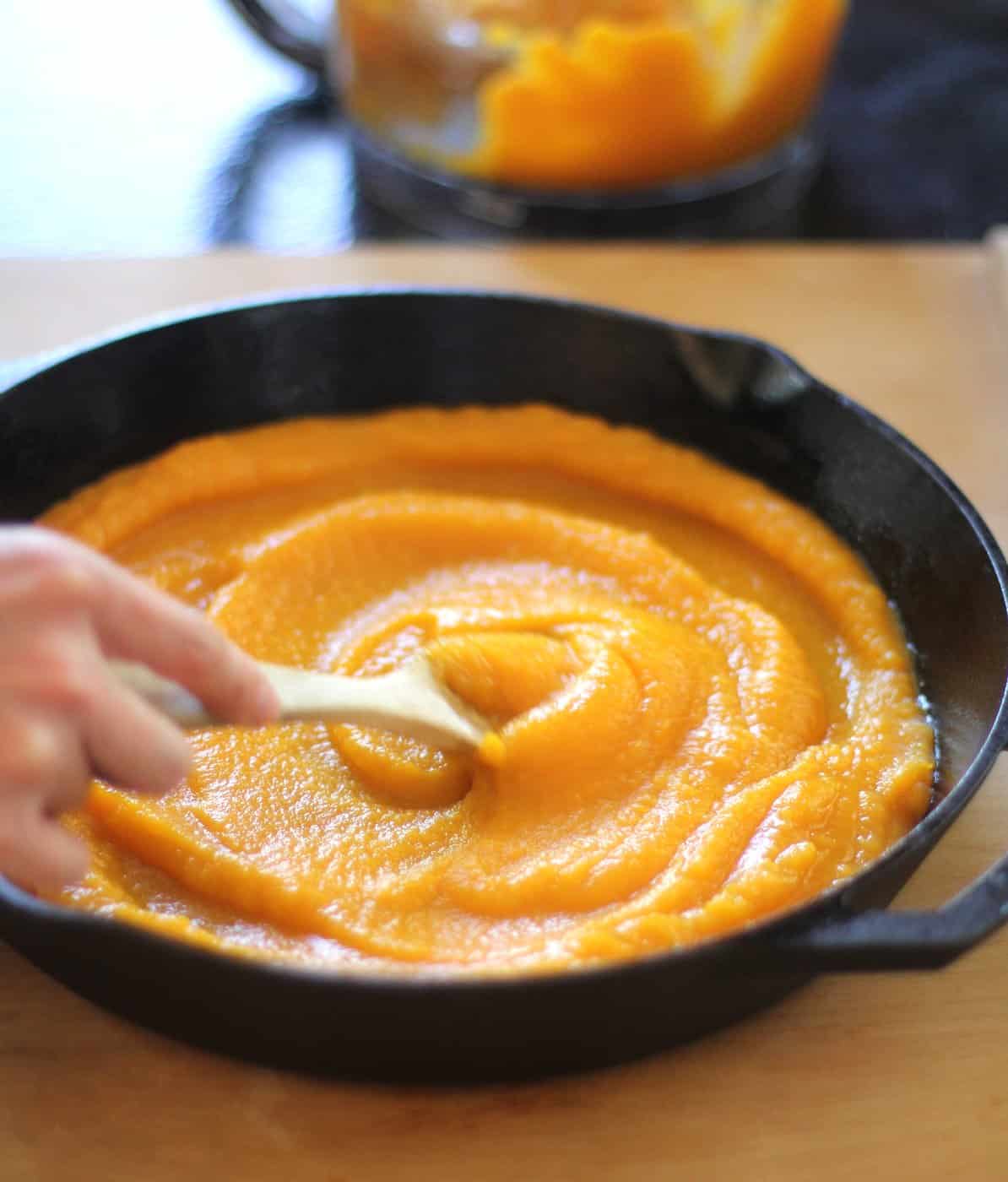 stirring Butternut Squash Sauce in a cast iron skillet