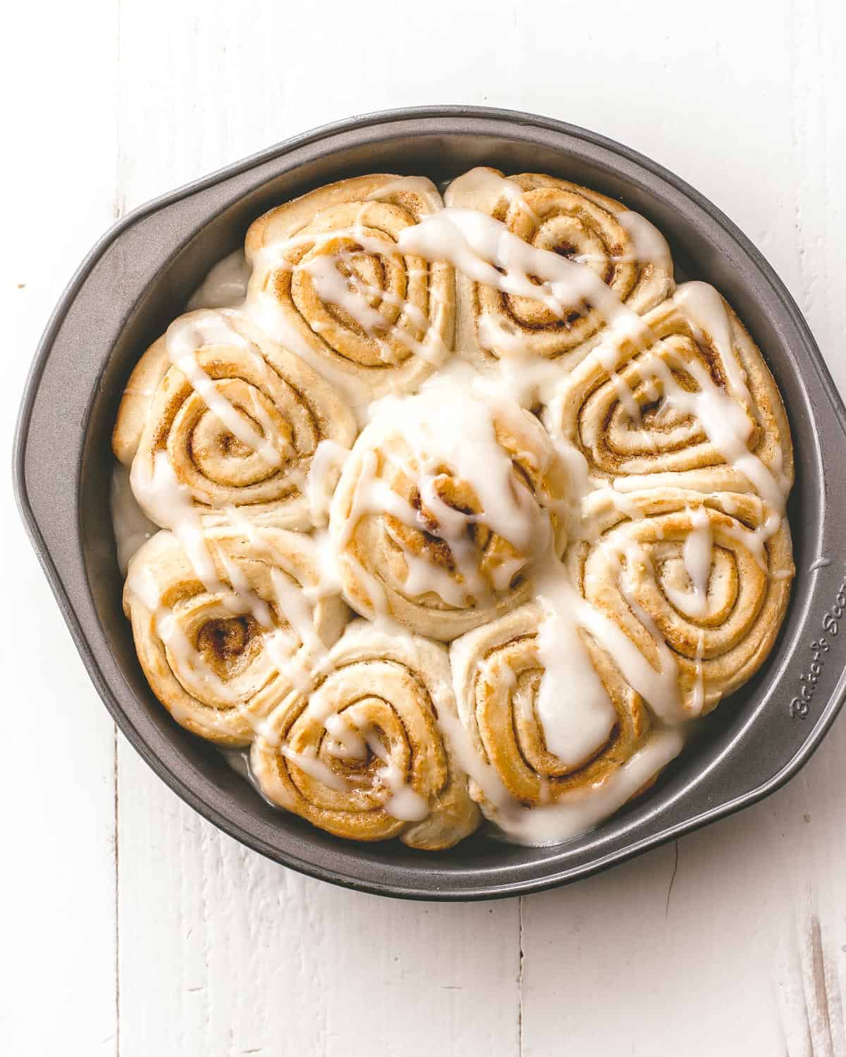 overhead image of cinnamon rolls in a round baking pan