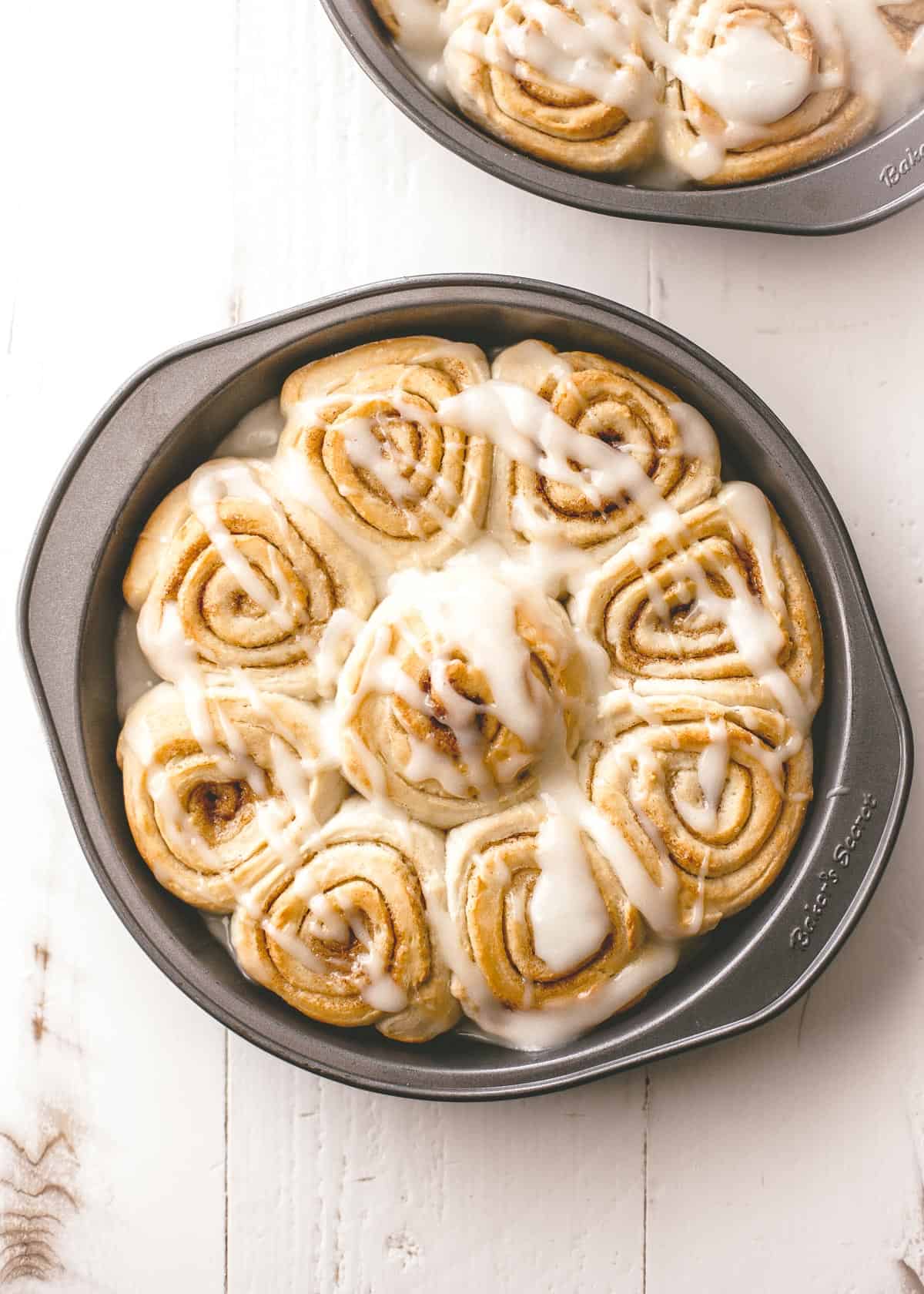 overhead image of cinnamon rolls in a round baking pan