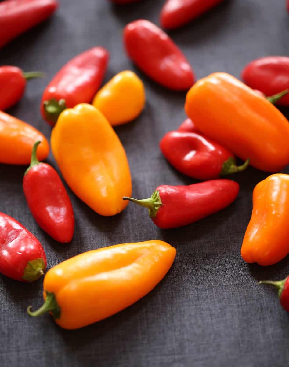 small peppers on a grey cutting board