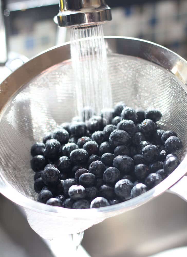 rinsing blueberries in a wire strainer